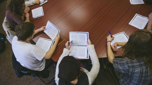 一群学生在圆桌上阅读文章