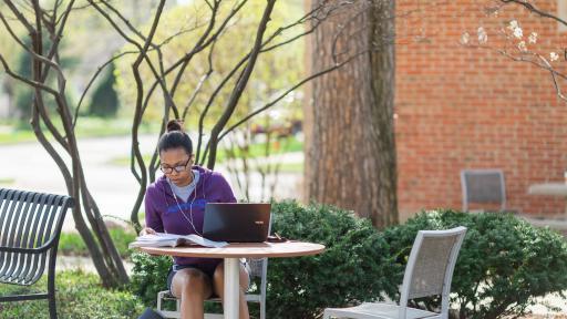 student sitting outside doing homework